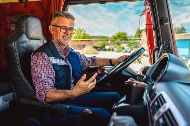 Professional mature truck driver driving truck vehicle.